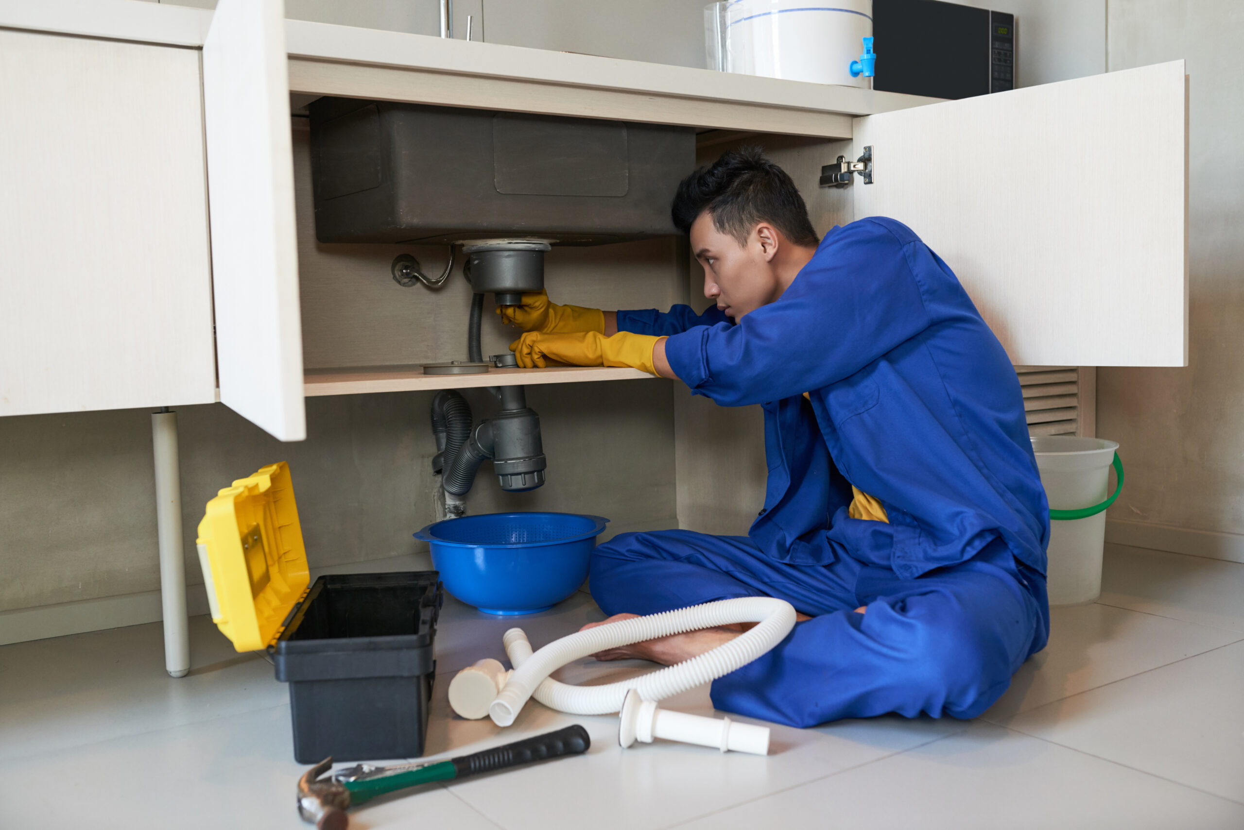 Alta plumber in blue overalls clearing a blocked drain in Bloomingdale IL